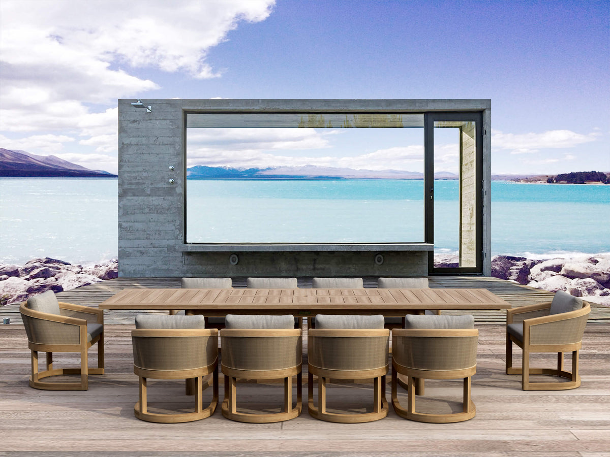 Outdoor dining area with a large flat-screen TV mounted on a wall overlooking a scenic lake.