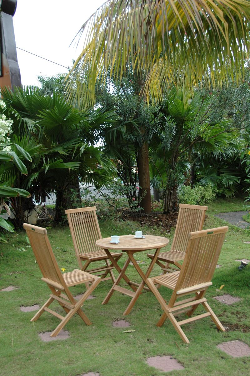 Wooden outdoor furniture set with four chairs around a small round table in a garden setting.