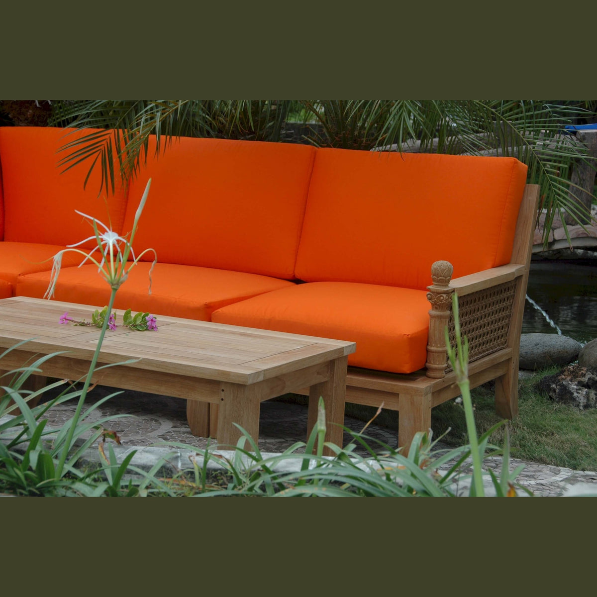 Orange outdoor sofa with wooden frame and table in a garden setting