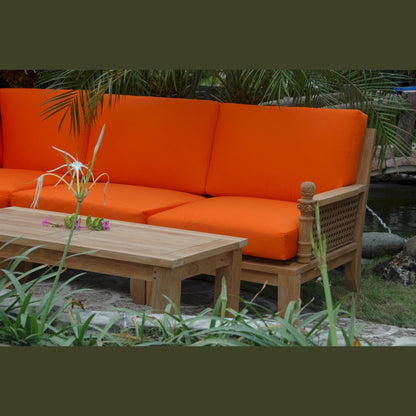 Orange outdoor sofa with wooden frame and table in a garden setting
