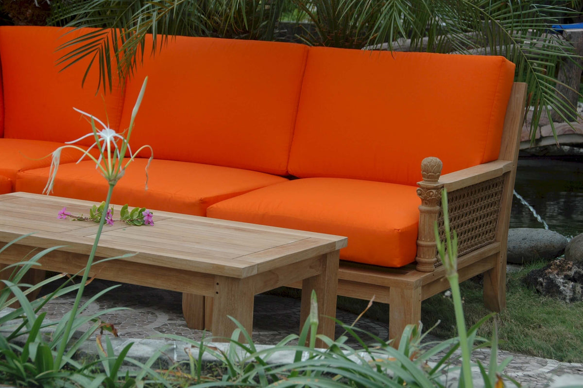 Orange outdoor sofa with wooden frame and table in a garden setting