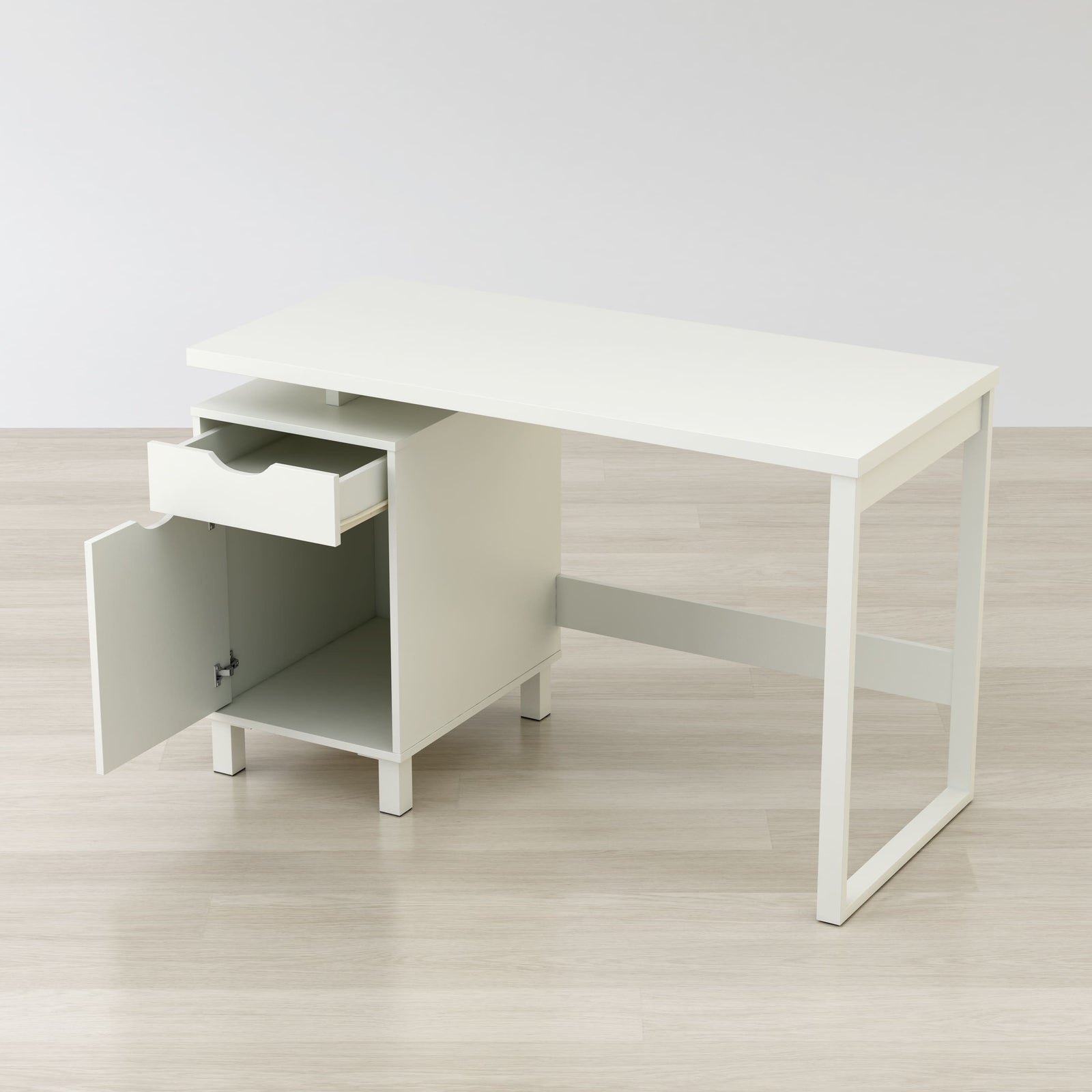 White office desk with a drawer on a light wooden floor.