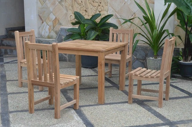Wooden outdoor dining set with four chairs on a stone patio.
