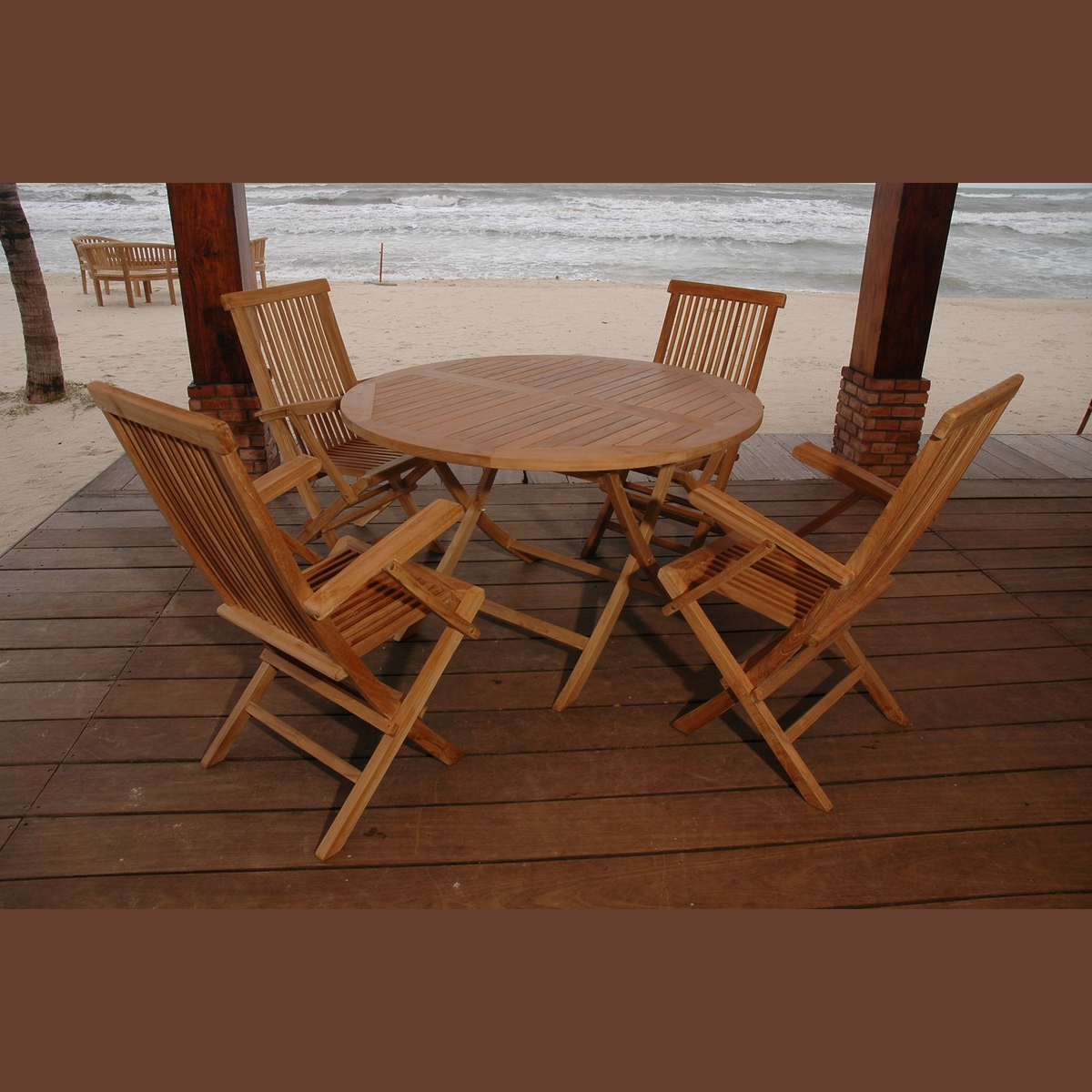 Wooden outdoor dining set on a deck with ocean view