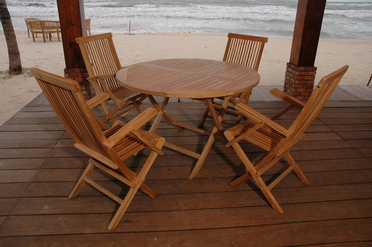 Wooden outdoor dining set on a deck with ocean view