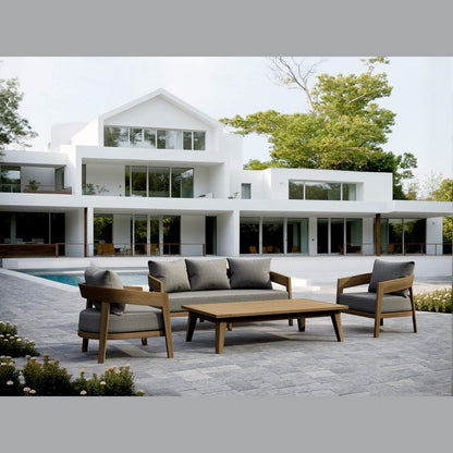 Modern outdoor furniture set on a patio in front of a white house with large windows.