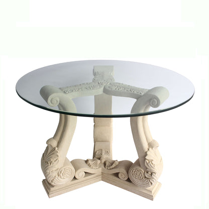 Decorative round table with glass top and ornate base on a white background
