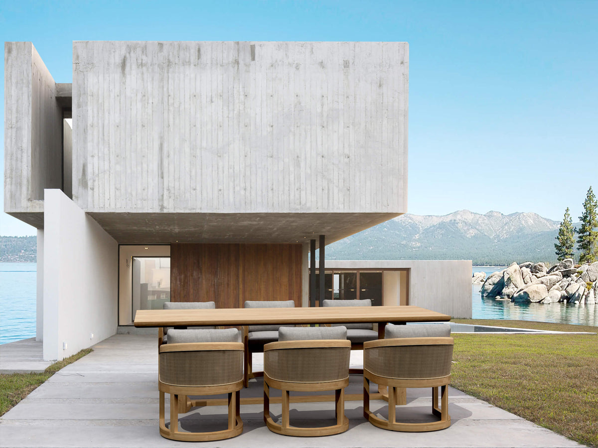 Modern house with a dining table and chairs by a waterfront