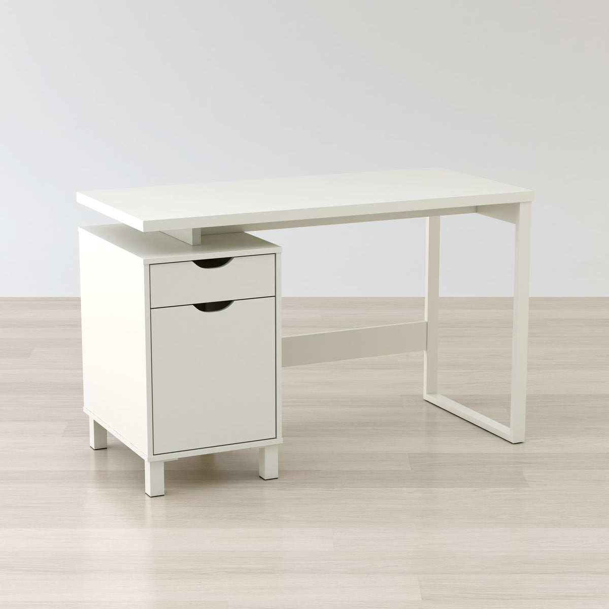 White desk with a drawer on a light wooden floor and white wall background