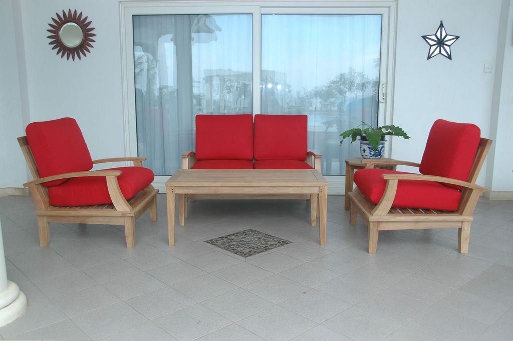 Outdoor furniture set with red cushions and a wooden table on a patio.