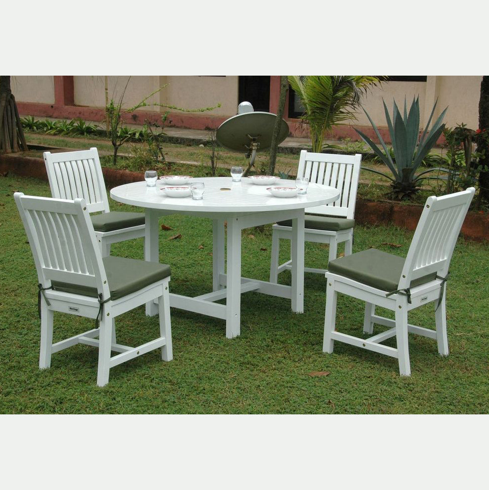 White outdoor dining set with four chairs and a round table on grass