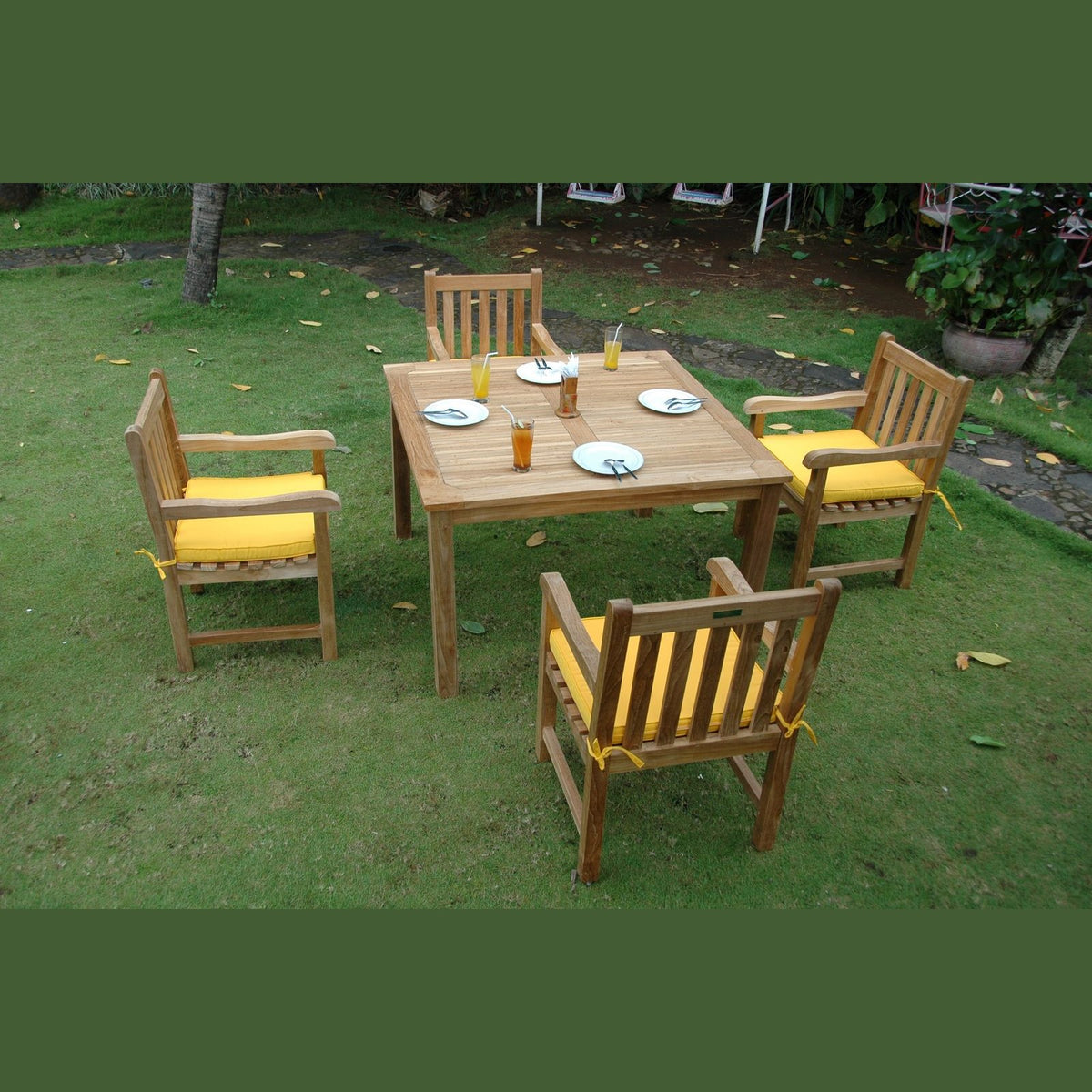 Wooden outdoor table with four chairs on a grassy area