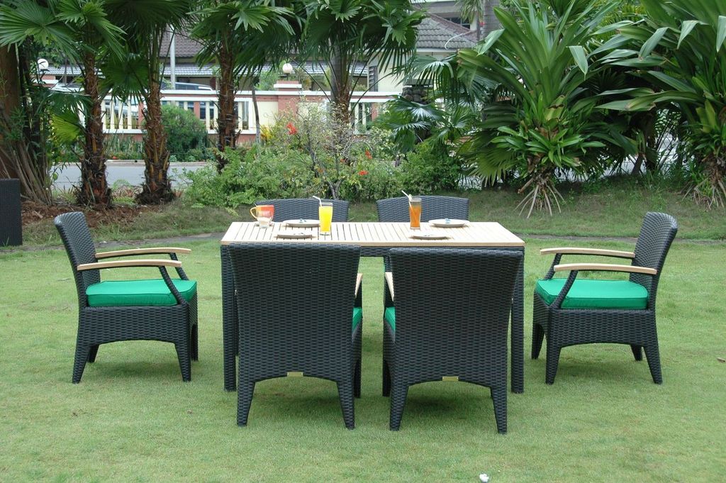 Black outdoor furniture set on a grassy area with greenery in the background