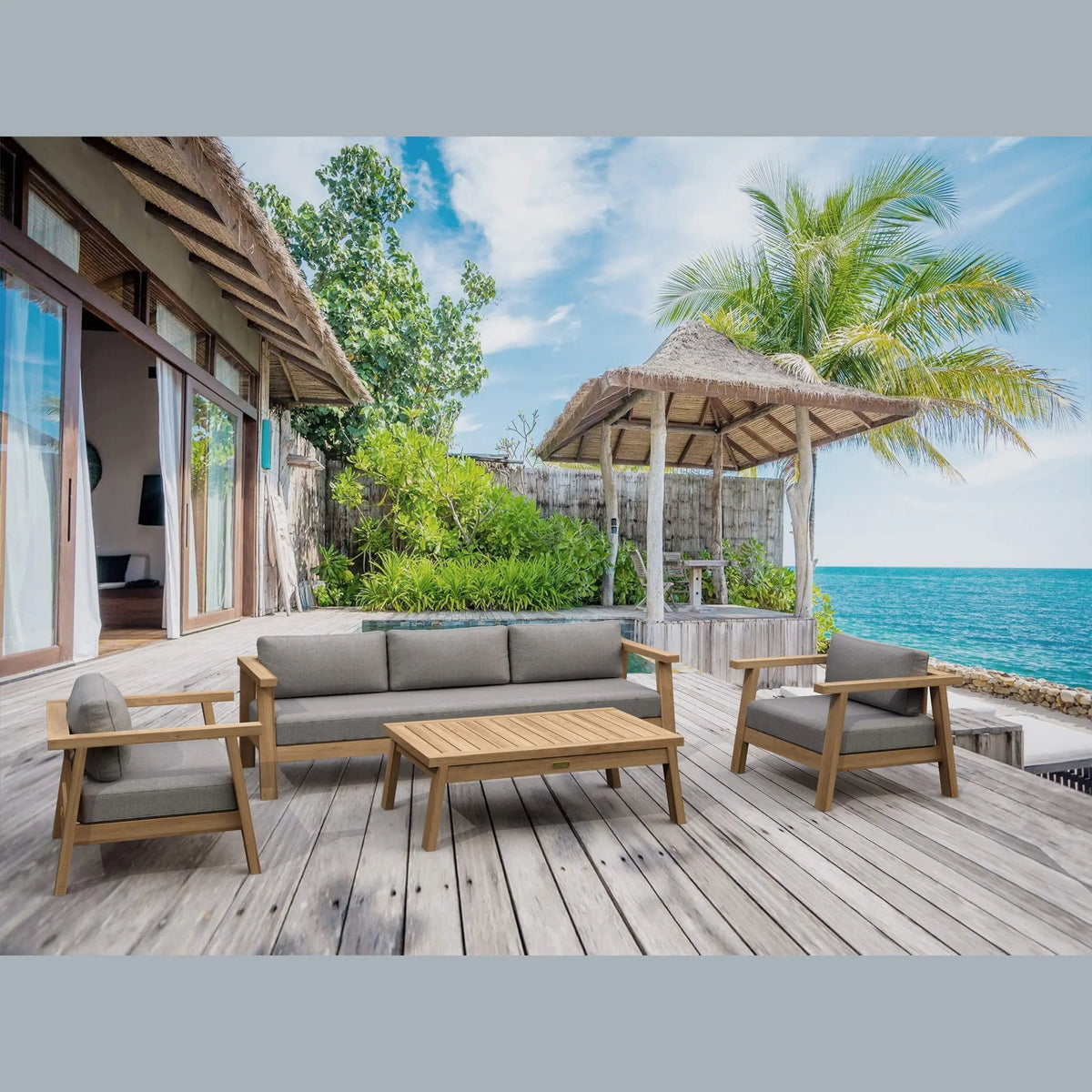 Outdoor seating area with wooden furniture on a deck overlooking the ocean.