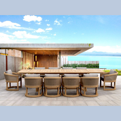Outdoor dining set with wooden table and chairs on a patio with ocean view.
