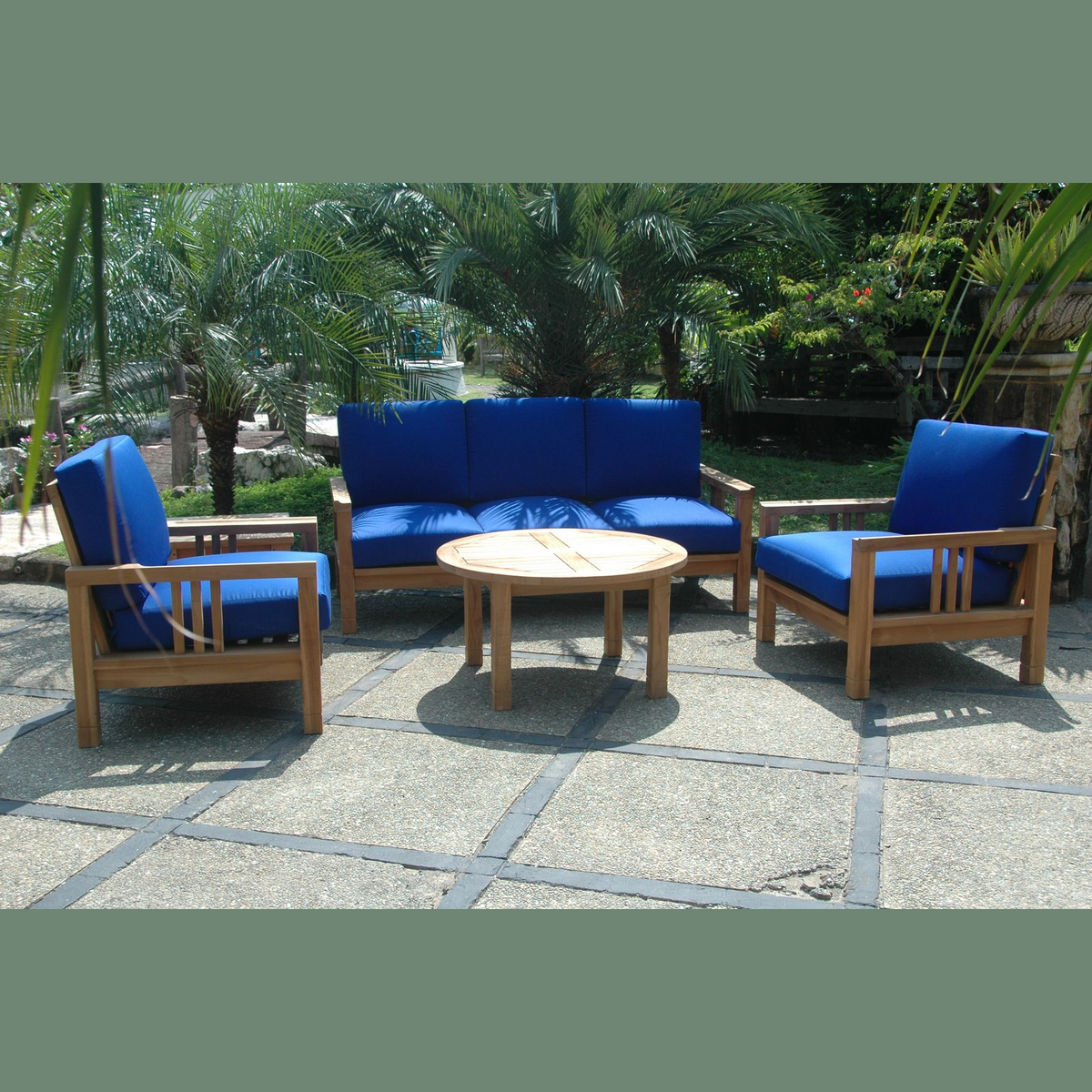 Outdoor furniture set with blue cushions on a stone patio