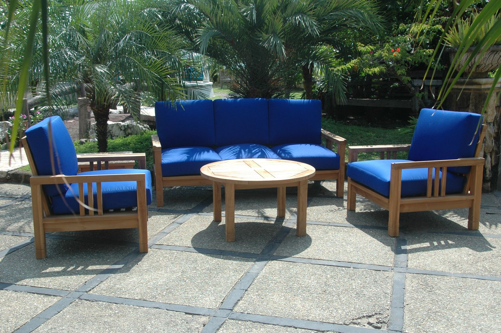 Outdoor furniture set with blue cushions on a stone patio