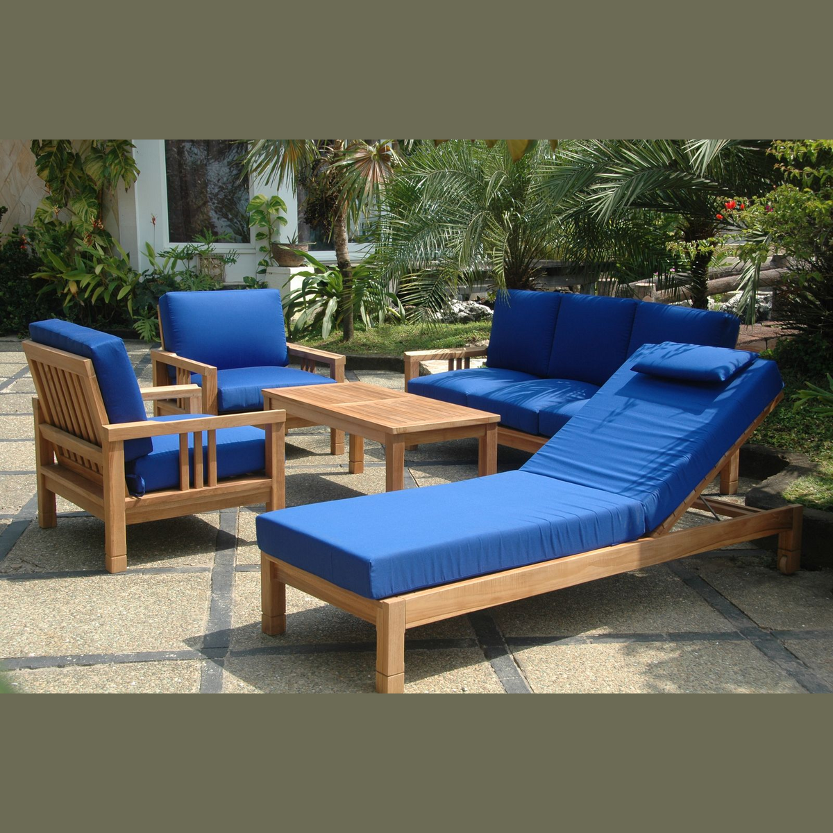 Outdoor furniture set with blue cushions and wooden frames on a patio.