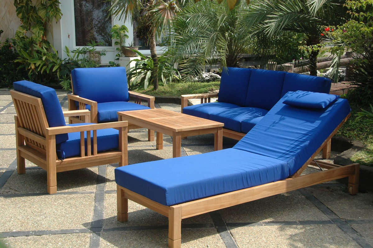 Outdoor furniture set with blue cushions and wooden frames on a patio.