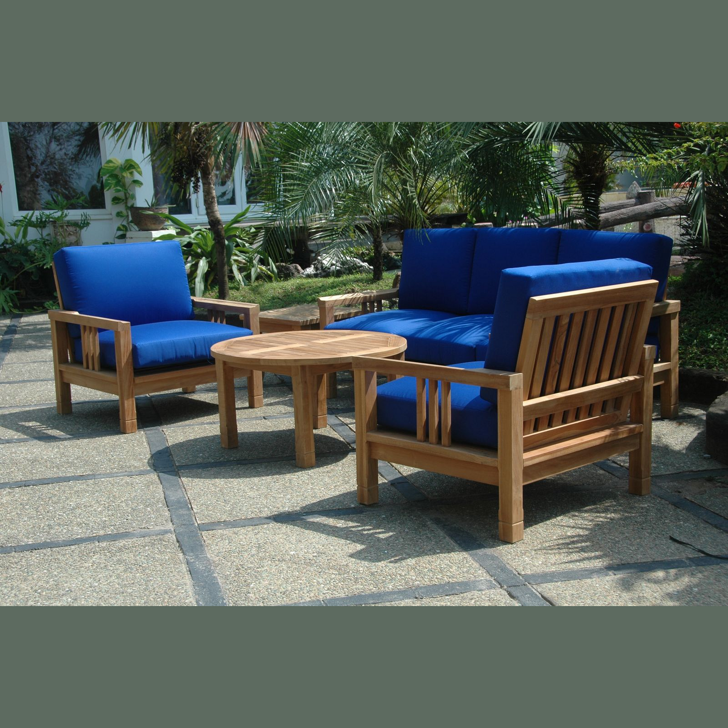 Outdoor furniture set with blue cushions and a wooden table on a patio.