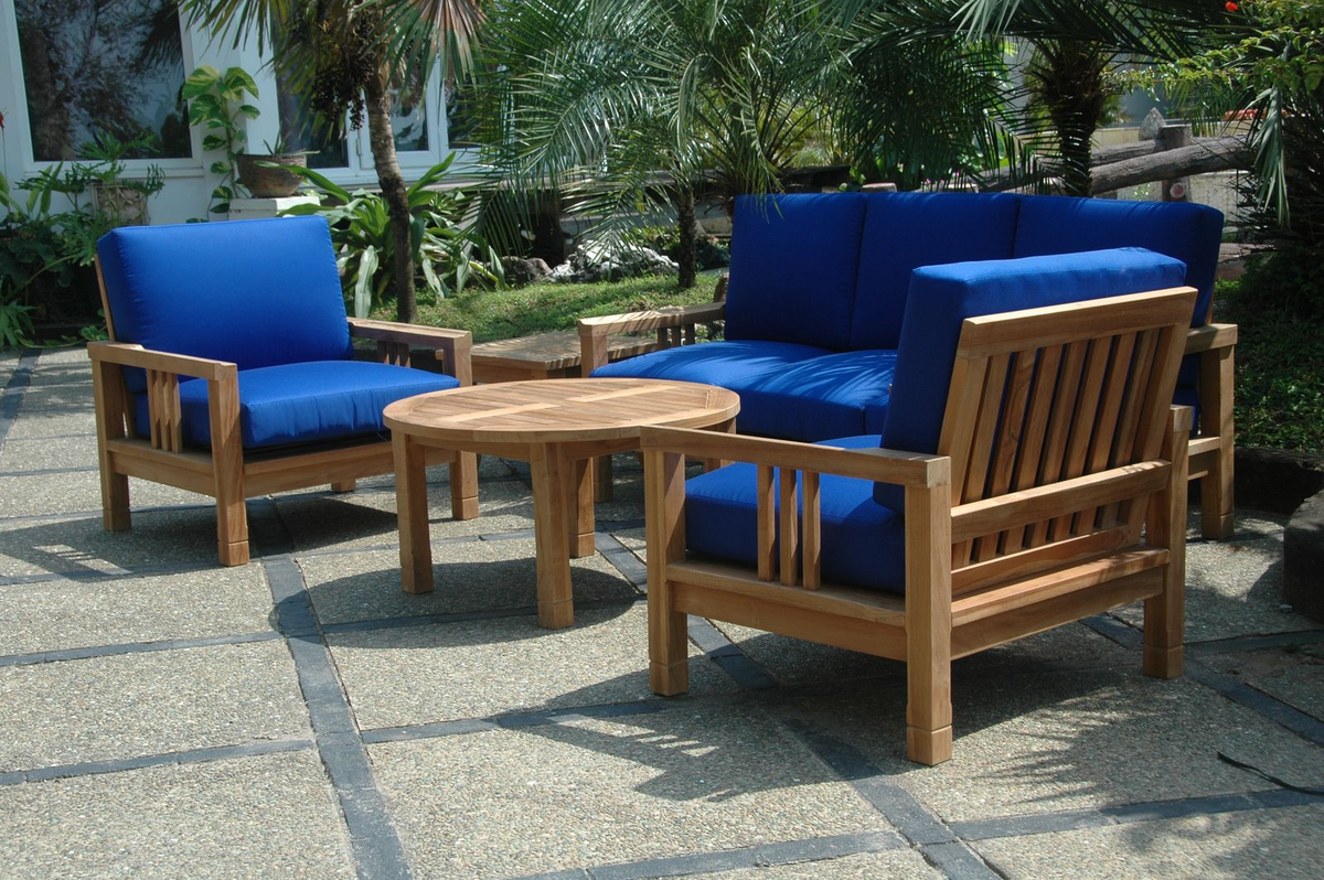 Outdoor furniture set with blue cushions and a wooden table on a patio.