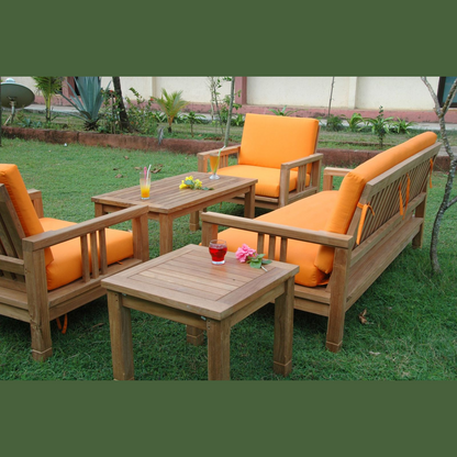 Garden furniture set with orange cushions on a grassy area