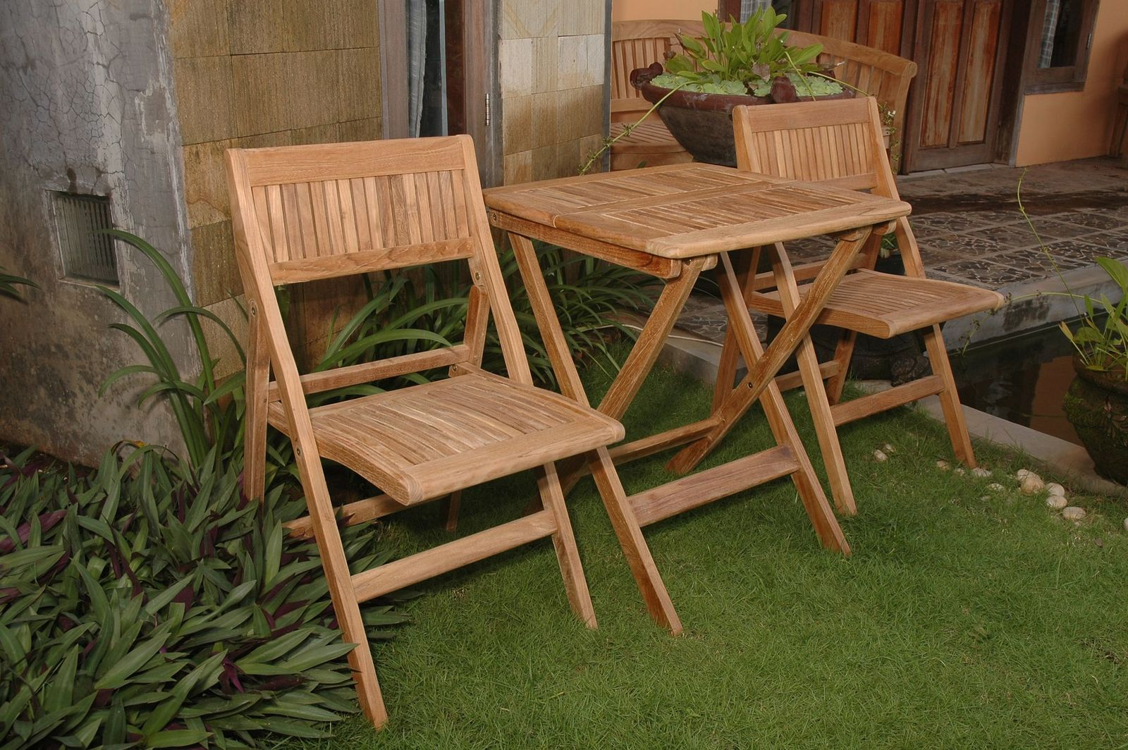 Wooden outdoor furniture set with table and chairs on a grassy area.