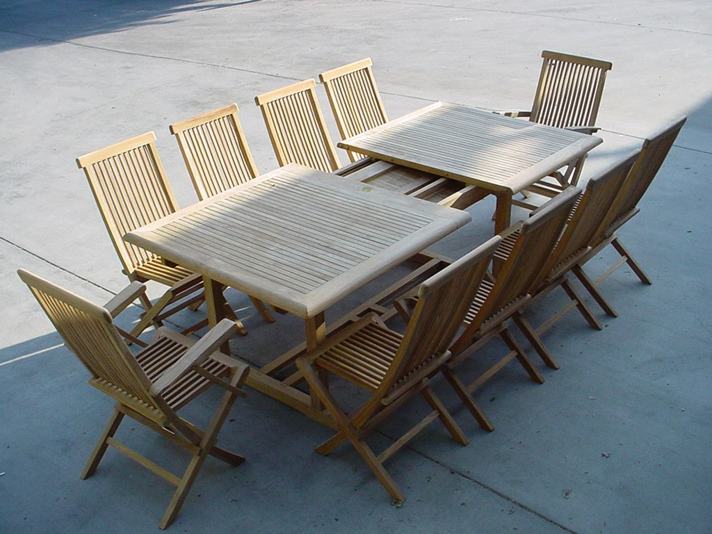 Outdoor teak furniture set with two tables and eight chairs on a concrete surface.