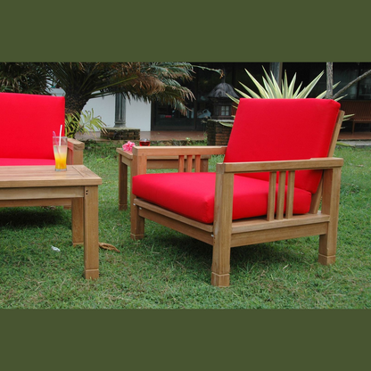 Wooden outdoor furniture set with red cushions on a grassy area.