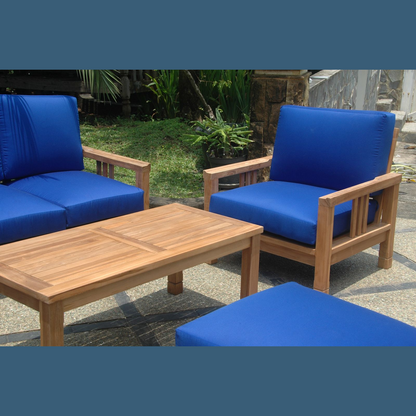 Outdoor furniture set with blue cushions and a wooden table on a patio.