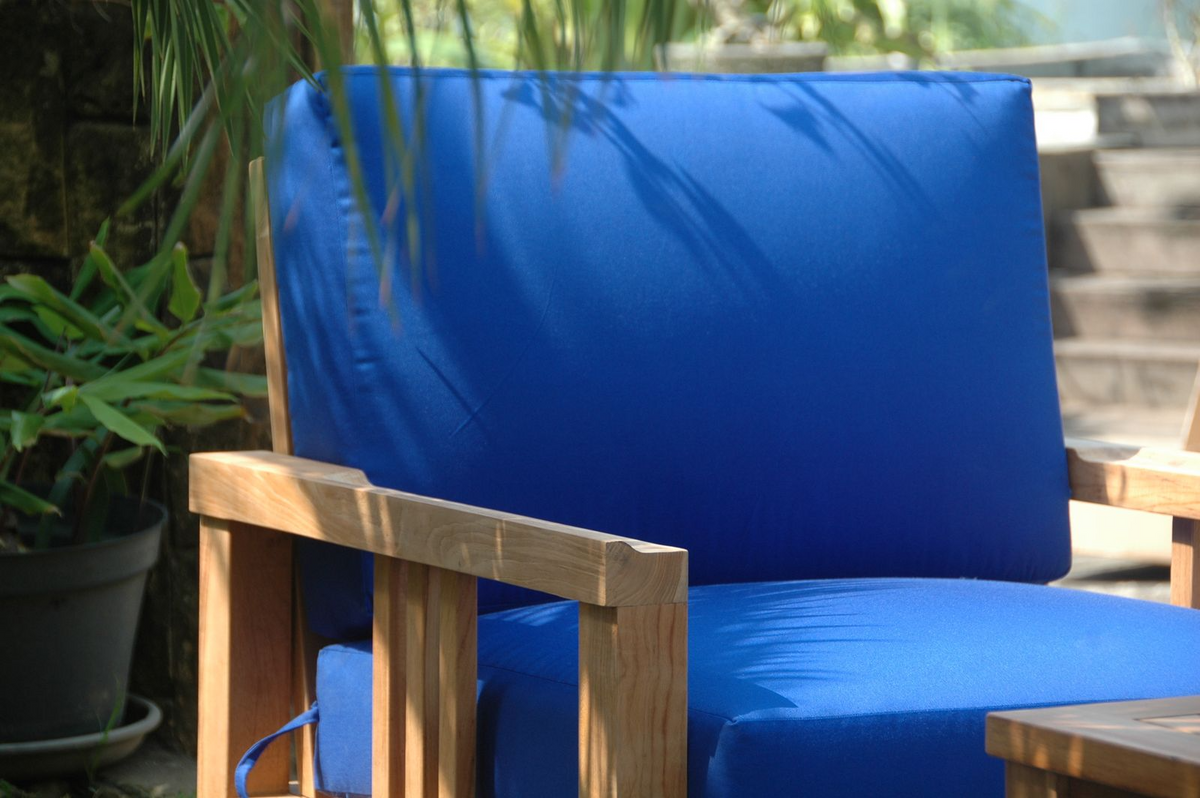 Blue cushioned chair with wooden frame in an outdoor setting