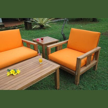 Outdoor furniture set with orange cushions on a grassy area
