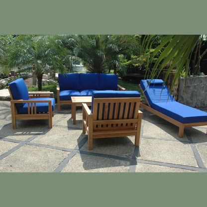 Outdoor patio furniture set with blue cushions on a stone patio.