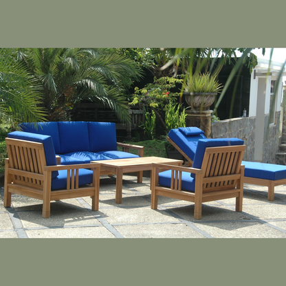 Outdoor furniture set with blue cushions and wooden frames in a garden setting.