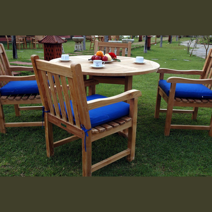 Wooden outdoor furniture set with blue cushions on a grassy area