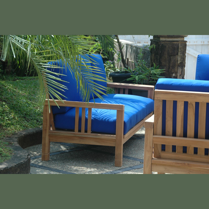 Wooden outdoor furniture with blue cushions in a garden setting