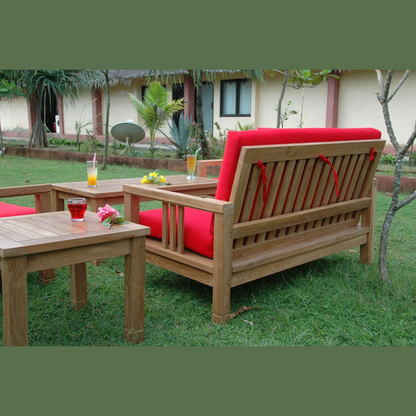 Wooden outdoor furniture set with red cushions on a grassy area.