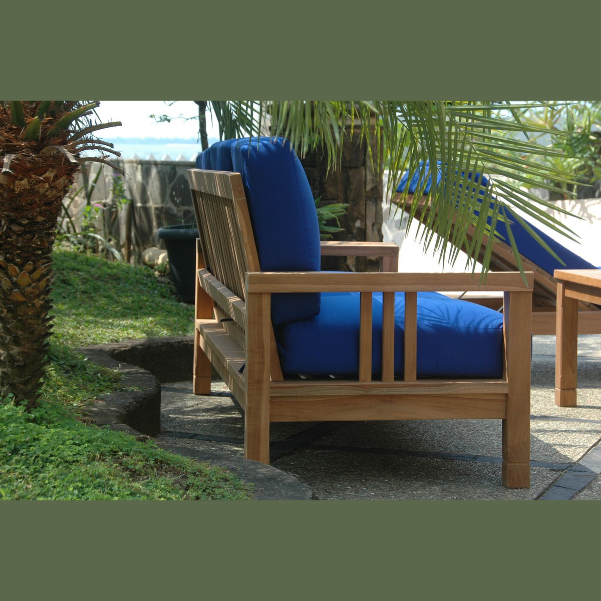 Wooden outdoor chair with blue cushions in a garden setting