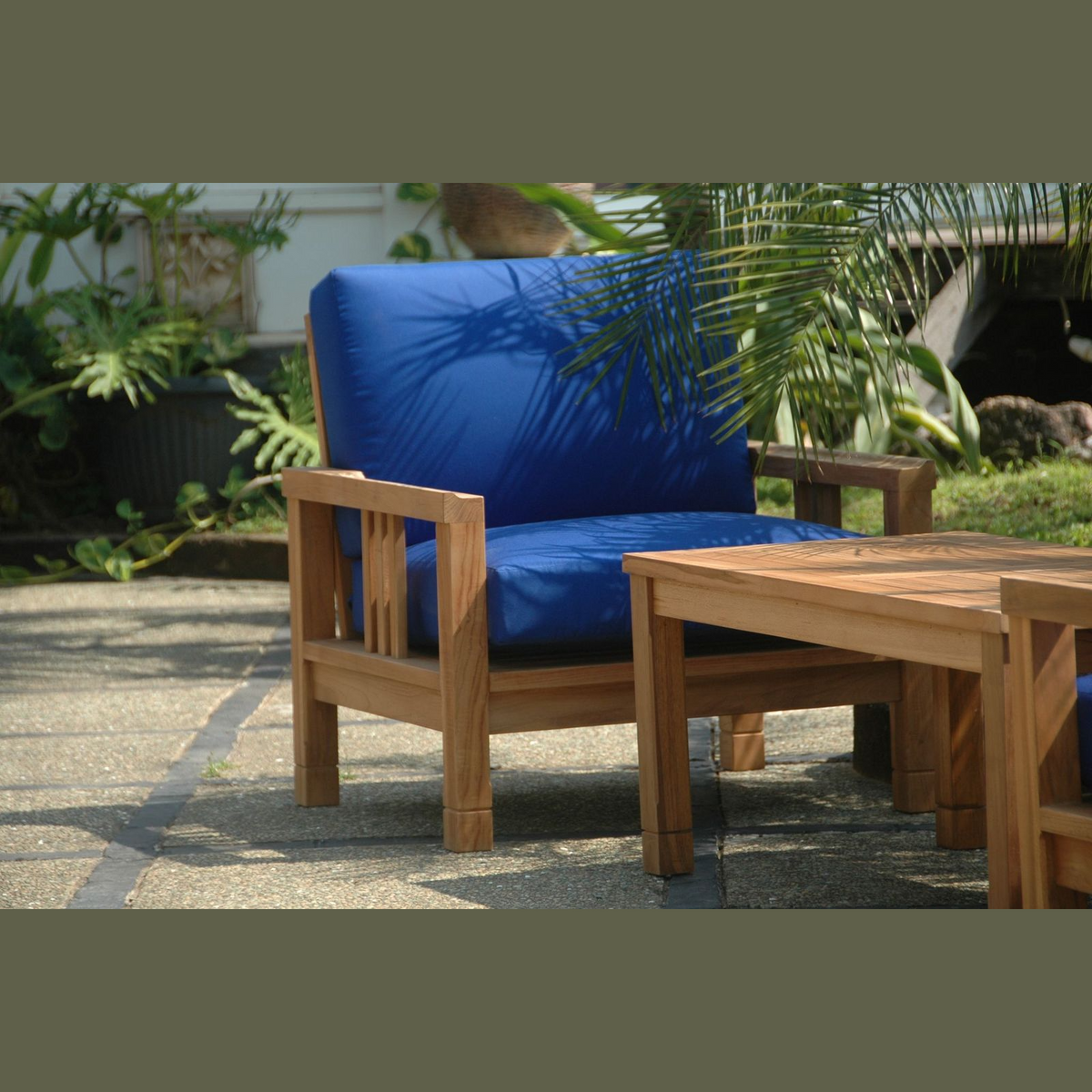Wooden outdoor furniture set with blue cushions on a patio