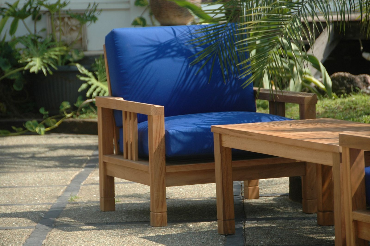 Wooden outdoor furniture set with blue cushions on a patio