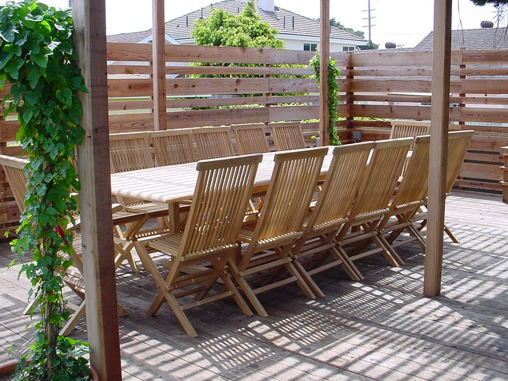 Wooden outdoor dining set with chairs and table on a deck