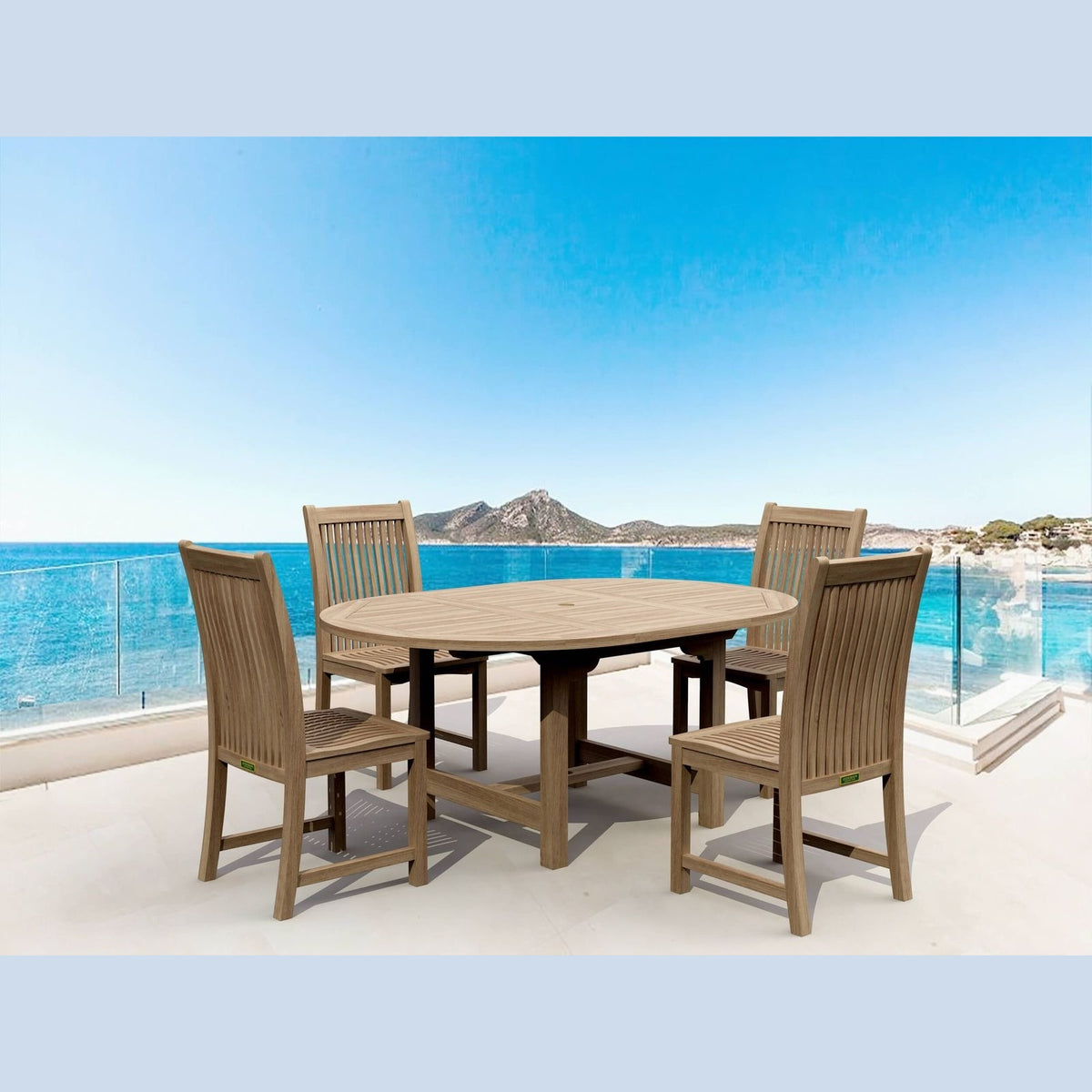Outdoor dining set with table and chairs on a balcony with a scenic view of water and mountains.