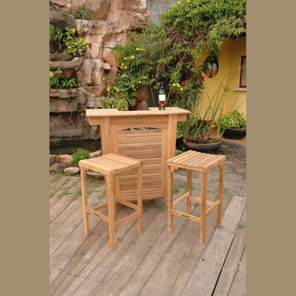 Wooden bar set with two stools on a wooden deck with garden and fountain in the background