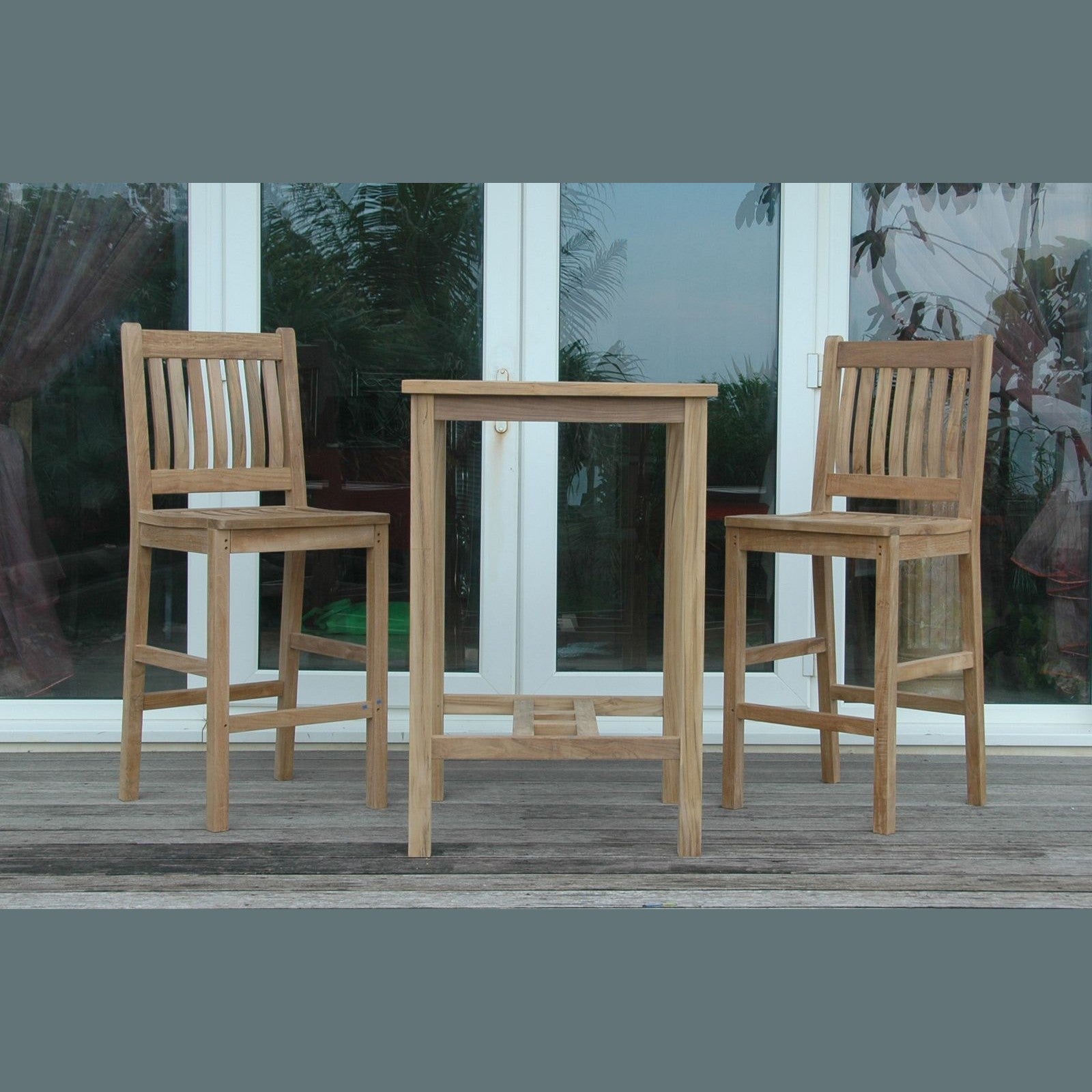 Wooden outdoor bar set with two stools and a table on a deck.