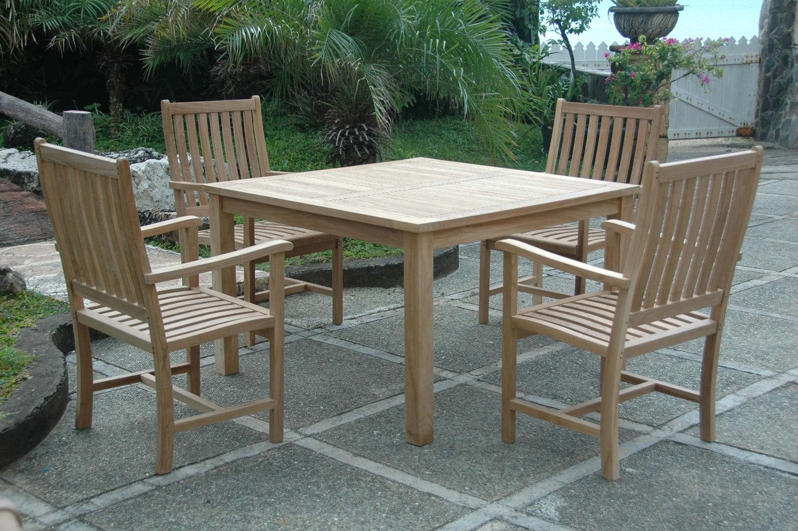 Wooden outdoor dining set with table and chairs on a stone patio
