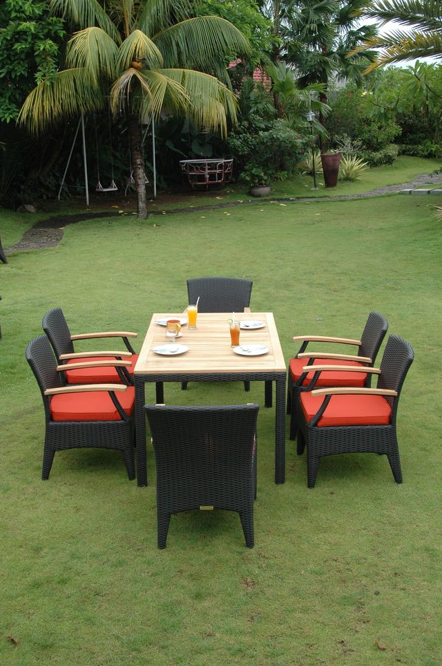 Outdoor dining set with table and chairs on a grassy area with palm trees in the background