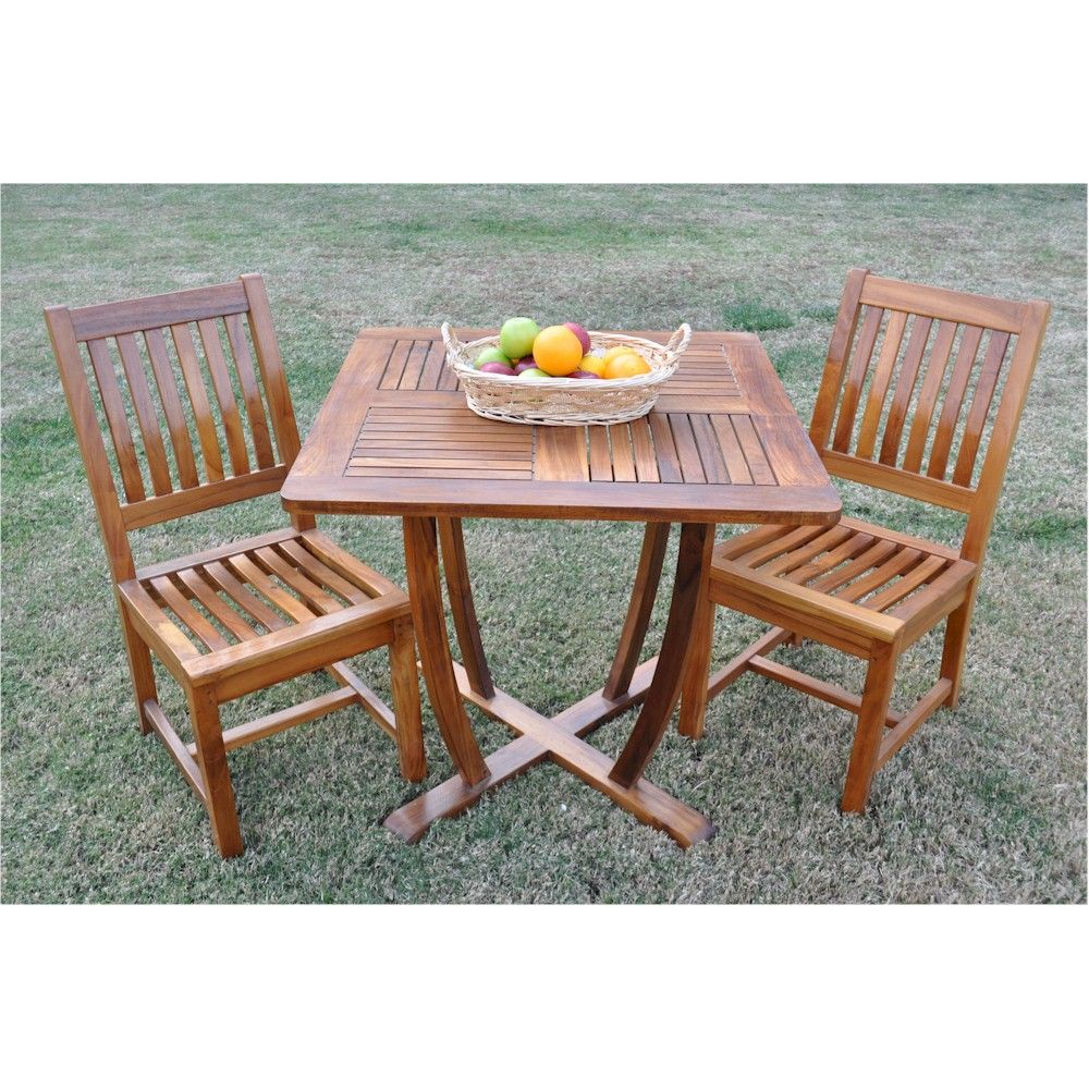 Wooden outdoor table with two chairs on a grassy area