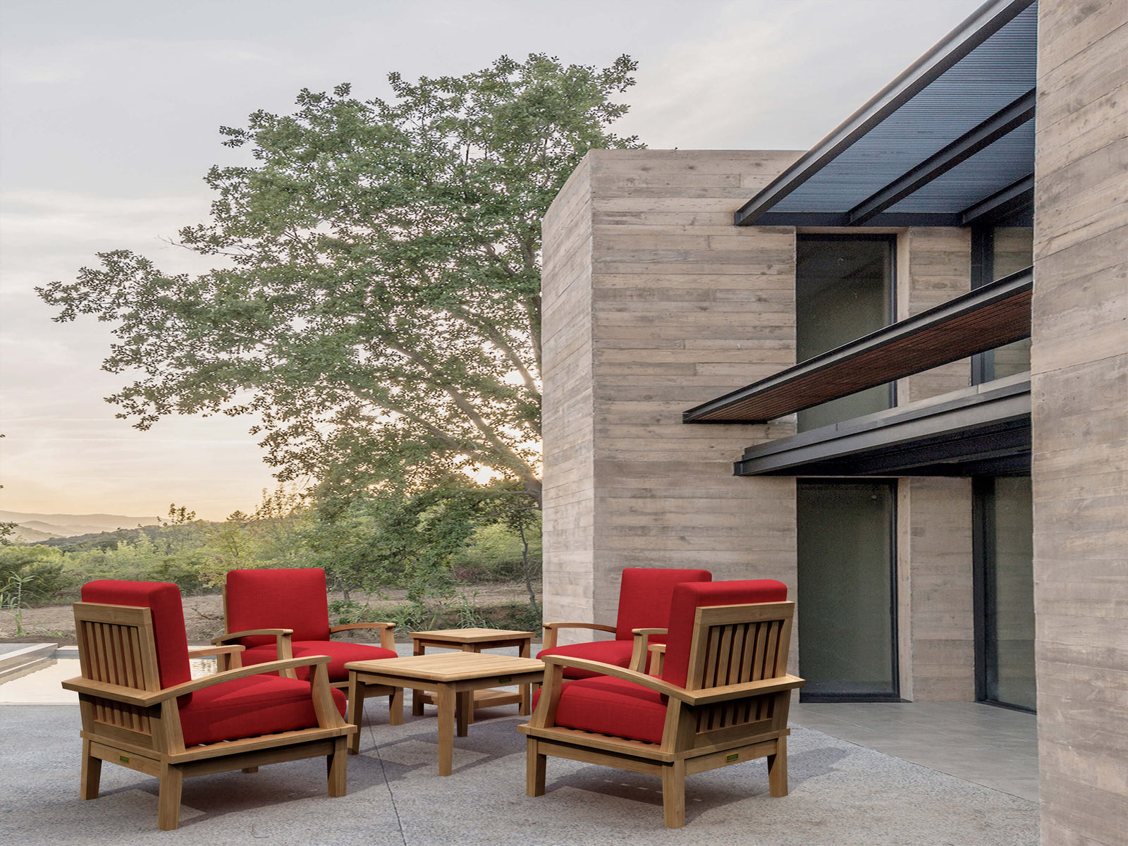 Outdoor furniture set with red cushions in front of a modern building.