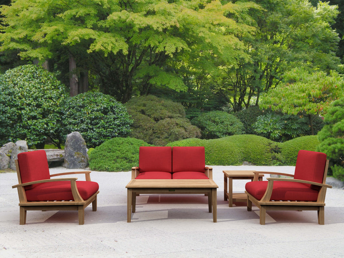 Outdoor furniture set with red cushions in a garden setting