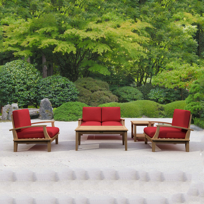 Outdoor furniture set with red cushions and wooden frames in a garden setting.